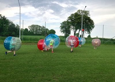 Chłopcy z klubu sportowego w krakowie grają w Bubble Football - piłkę nożną w kulach