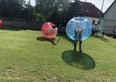 Gramy w Bubble Football w Łodzi na trawiastym boisku. Jeden z uczestników wykonuje salto